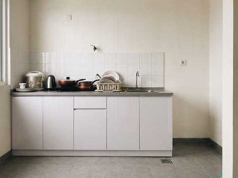 Sebelum — dapur bawaan developer sepanjang 1,8 m tanpa kabinet atas dan tanpa penyimpanan tertutup