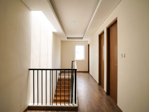 Koridor lantai dua dengan railing besi hollow finishing powder coating dan pelapis tangga kayu solid