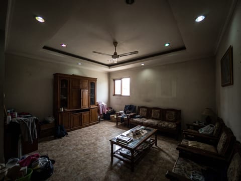 Sebelum — ruang keluarga dengan drop ceiling lama mengelilingi ruang dan hanya satu jendela kecil