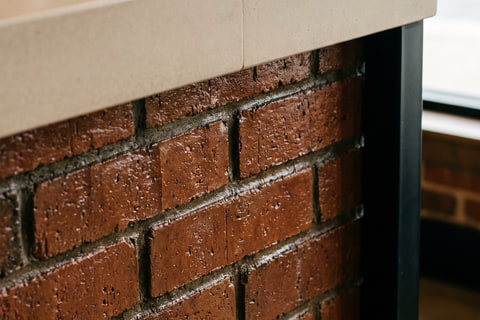 Detail pertemuan top solid surface bar dengan panel depan bata ekspos berfinishing coating bening