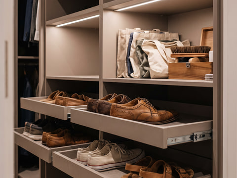 Rak sepatu tarik pada sisi kanan lorong closet dengan ambalan HPL warm grey di atasnya