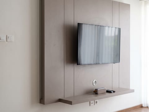 Panel dinding TV 2,4 meter lari berfinishing HPL warm grey pada kamar tidur utama