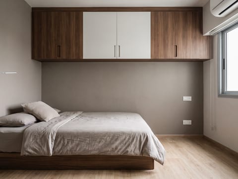 Area tidur unit studio dengan penyimpanan tinggi 60 cm di atas tempat tidur berfinishing HPL walnut