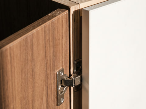 Detail pintu kabinet HPL walnut dengan edging PVC 2 mm dan engsel soft-close komponen standar pasaran