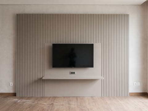 Backdrop TV 3,4 meter lari berfinishing HPL dengan bidang alur dan kabel tertanam di dalam panel