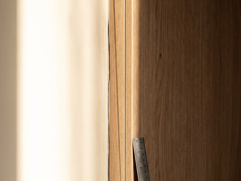Detail tepi panel lemari dengan edging PVC 2 mm dan sambungan panel pada dinding yang tidak siku