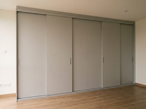 Lemari pakaian 6,2 meter lari berfinishing HPL dengan pintu geser, dipasang di kamar rumah tinggal
