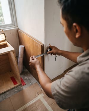 Interior designer mengukur bidang dinding pada unit hunian saat pendampingan instalasi